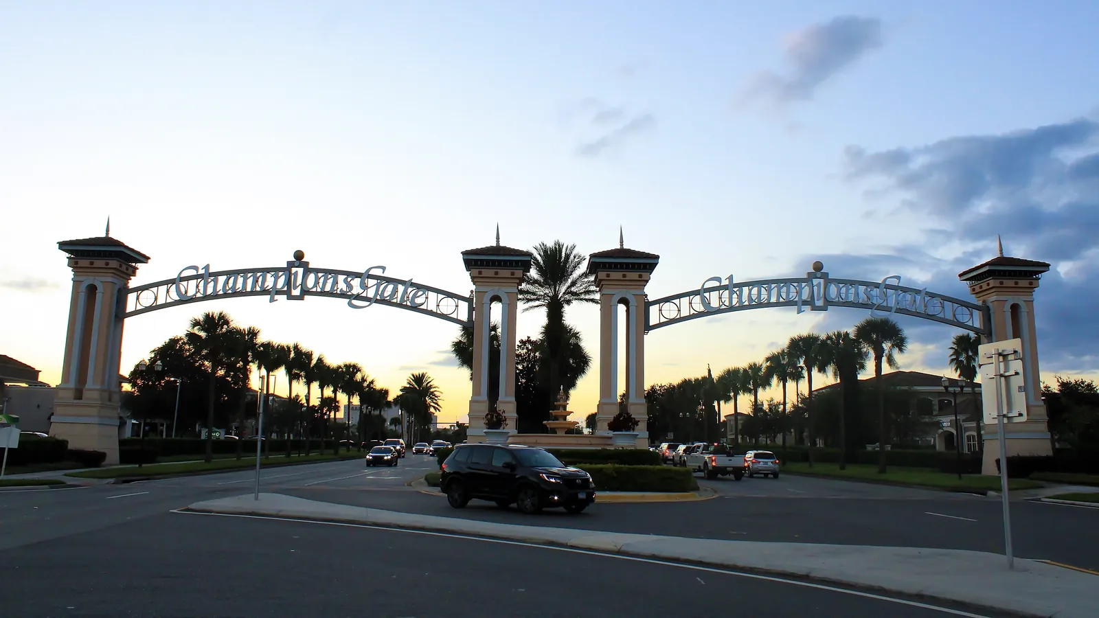 The ChampionsGate entrance arches and palm trees at dusk