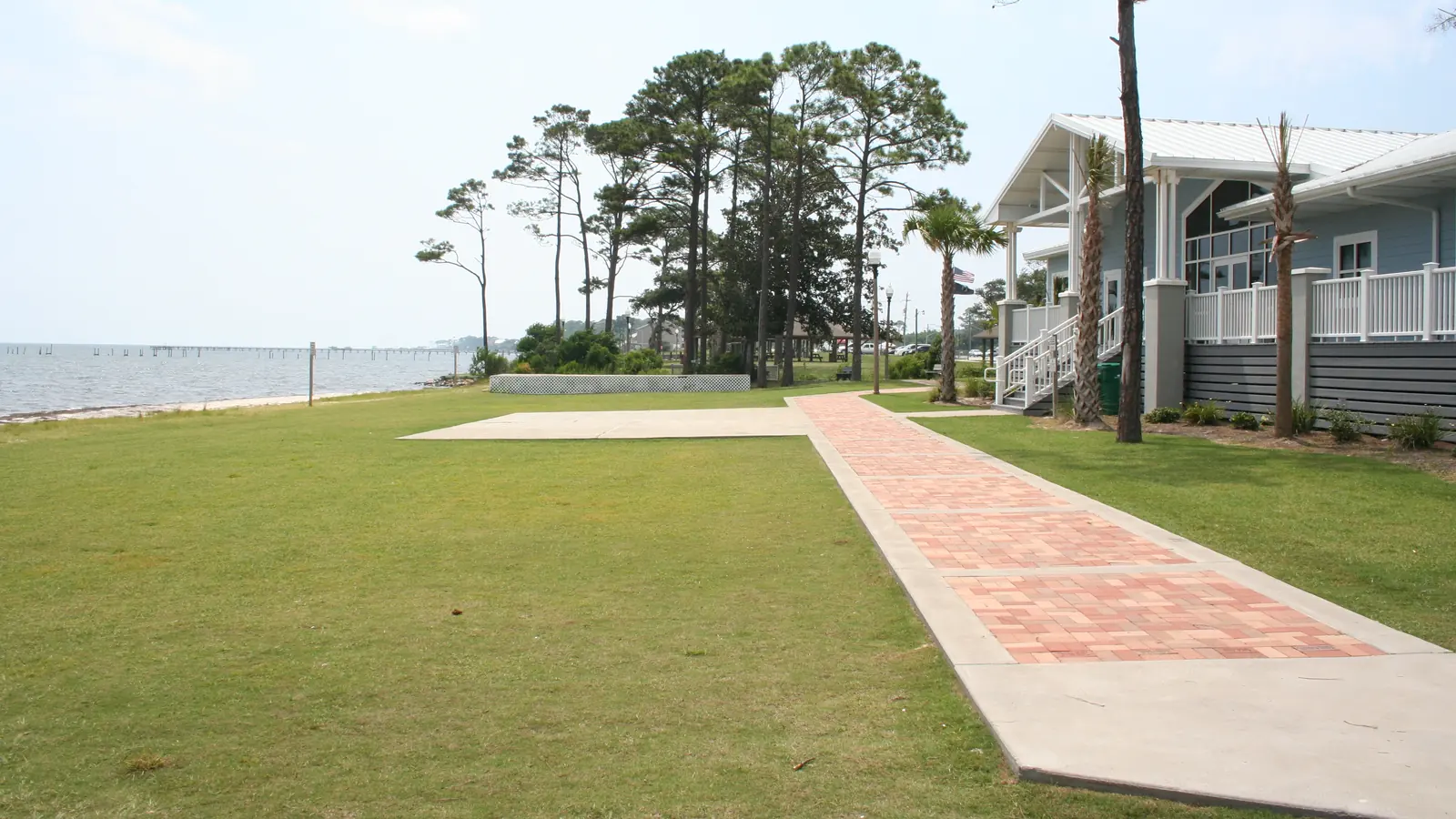 A brick path and lawn at Navarre Park by the water in Navarre, Florida