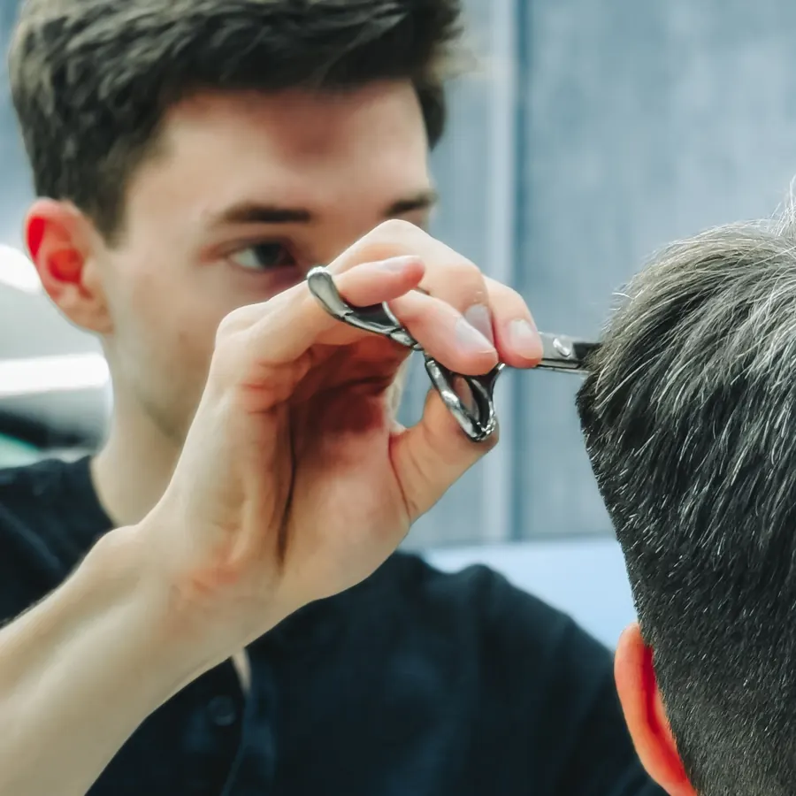 Barber standing by a client in a modern barbershop