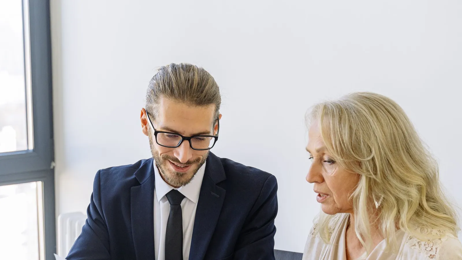 Consultant reviewing charts and documents with a client at a meeting table