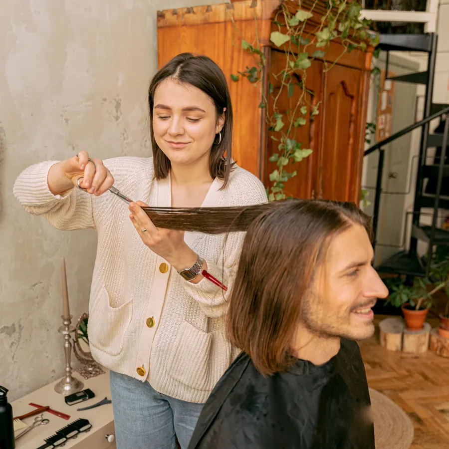 Stylist sectioning a client's hair in a cozy salon