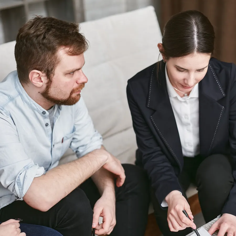 Agent going over paperwork with a client on a couch