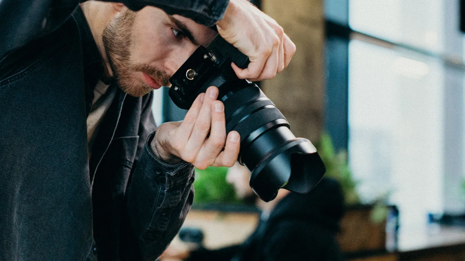 Photographer looking down into a medium-format camera in a bright studio