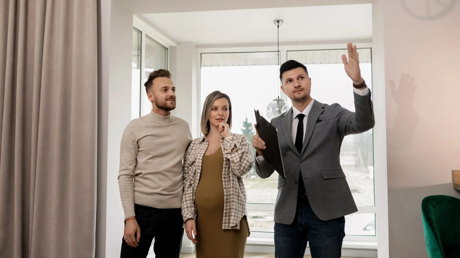 Real estate agent showing a home to a young expecting couple