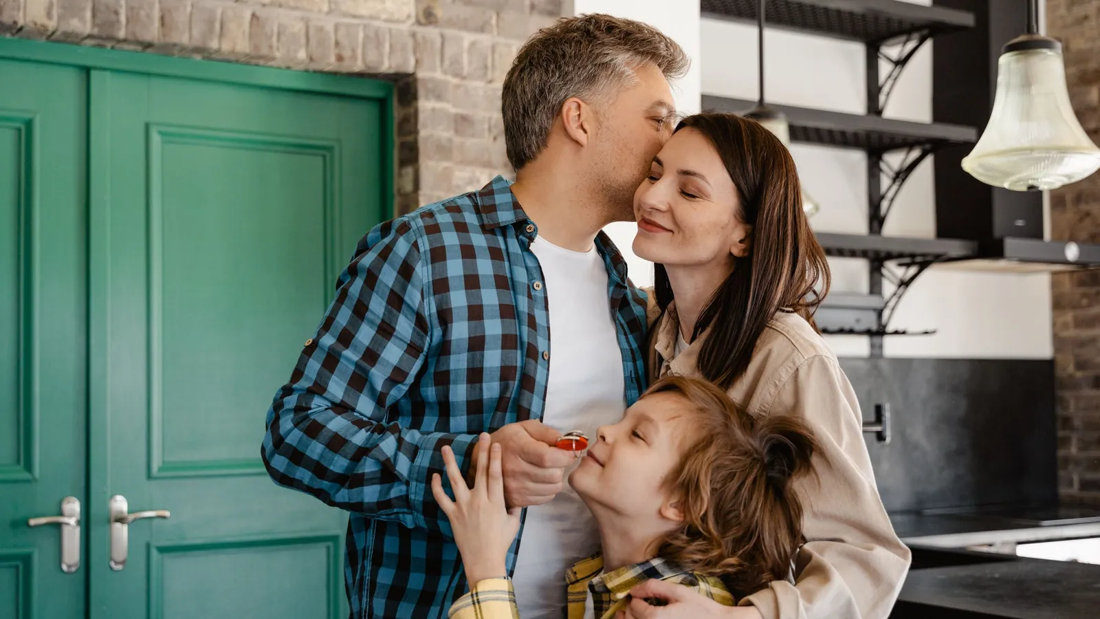 Family hugging in the kitchen doorway of their home