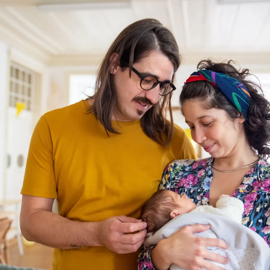 Two parents looking down at their newborn baby