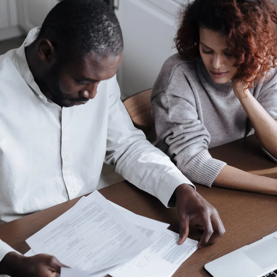 Couple reading insurance papers together at a kitchen table