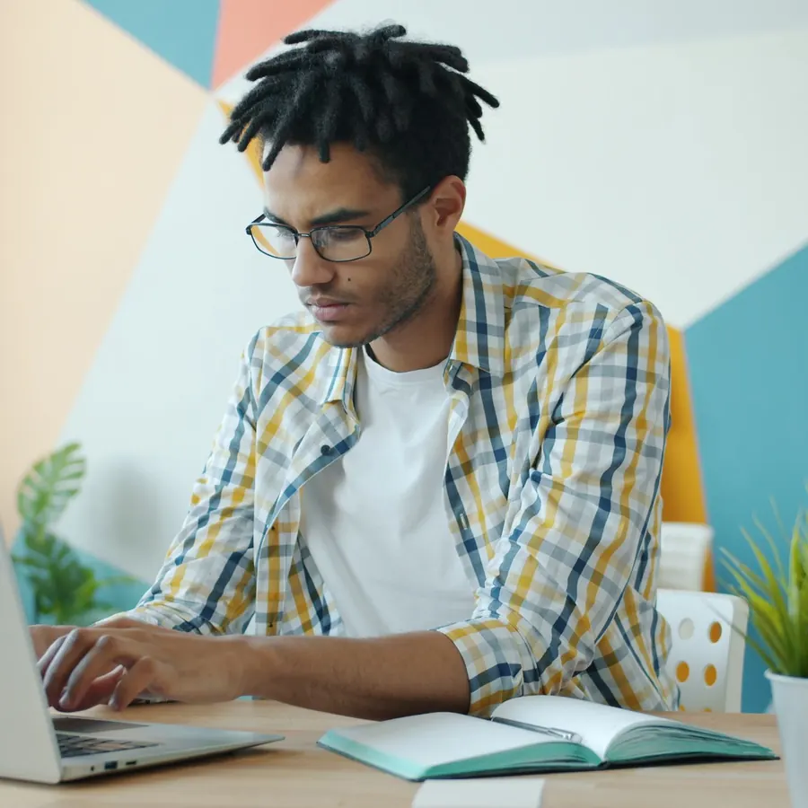 Young professional focused on a laptop at a bright desk