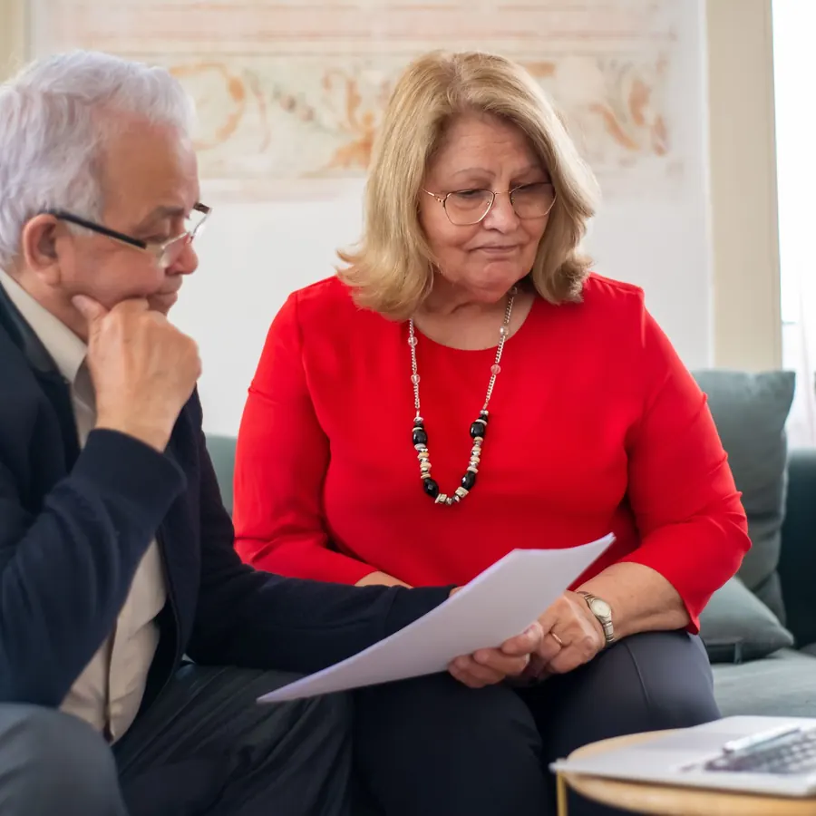 Older couple reviewing a document together on a sofa